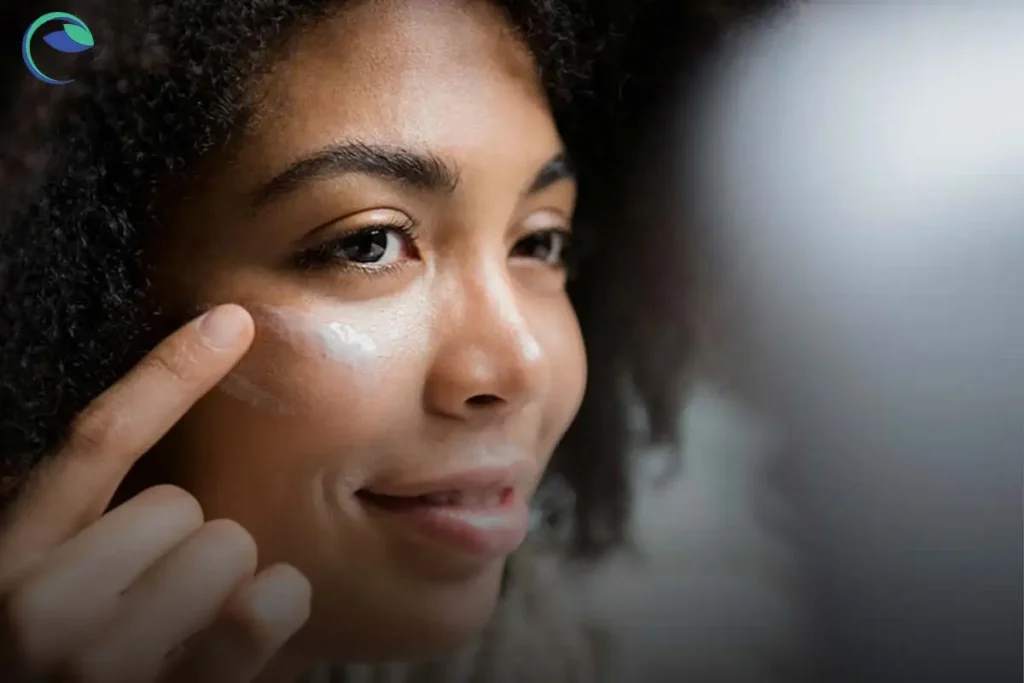 خانم سیاه پوستی که در حال مالیدن بهترین مارک ضد آفتاب فیزیکی خارجی روی پوست صورت خود است.